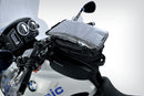 The mounting system is attached to the vehicle with minimal hand pressure and the tank bag can be quickly fastened to it. 