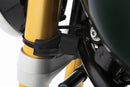 Limit and dampen the steering angle in the event of a fall, even before the standard steering stops are reached with full force